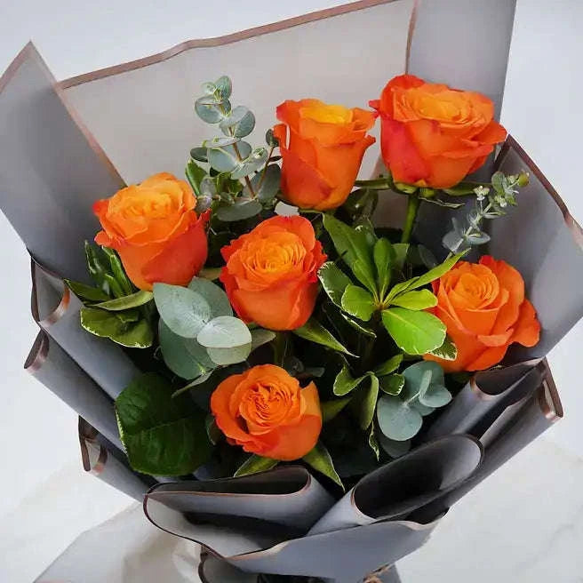 تنسيقة الورد الجوري البرتقالي مع البيتوسبوروم والأوكالبتوس والروسكوس flowerna