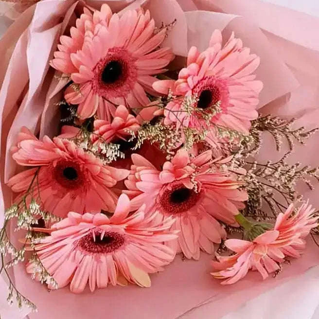 باقة زهور الجيربيرا الوردي مع الليمونيوم بتغليف فاخر flowerna