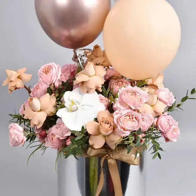 تنسيقة الورد الجوري الكابوتشينو والأوركيد مع البالونات في صندوق فضي flowerna