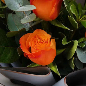 تنسيقة الورد الجوري البرتقالي مع البيتوسبوروم والأوكالبتوس والروسكوس flowerna