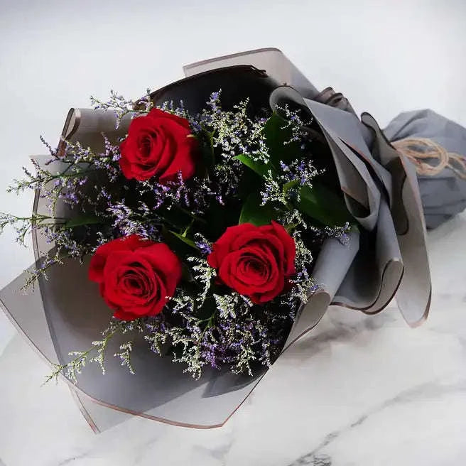 تنسيقة الورد الجوري الأحمر مع الليمونيوم والروسكوس بتغليف مميز flowerna