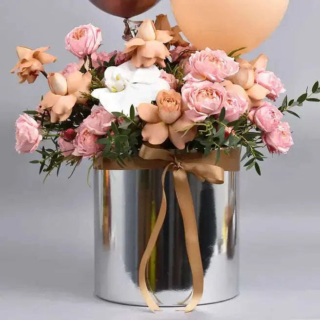 تنسيقة الورد الجوري الكابوتشينو والأوركيد مع البالونات في صندوق فضي flowerna