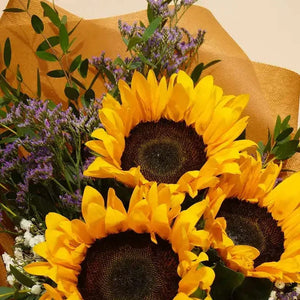 باقة عباد الشمس المشرقة مع الليمونيوم البنفسجي والجبسوفيليا flowerna