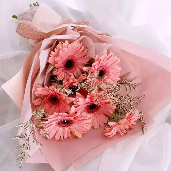باقة زهور الجيربيرا الوردي مع الليمونيوم بتغليف فاخر flowerna