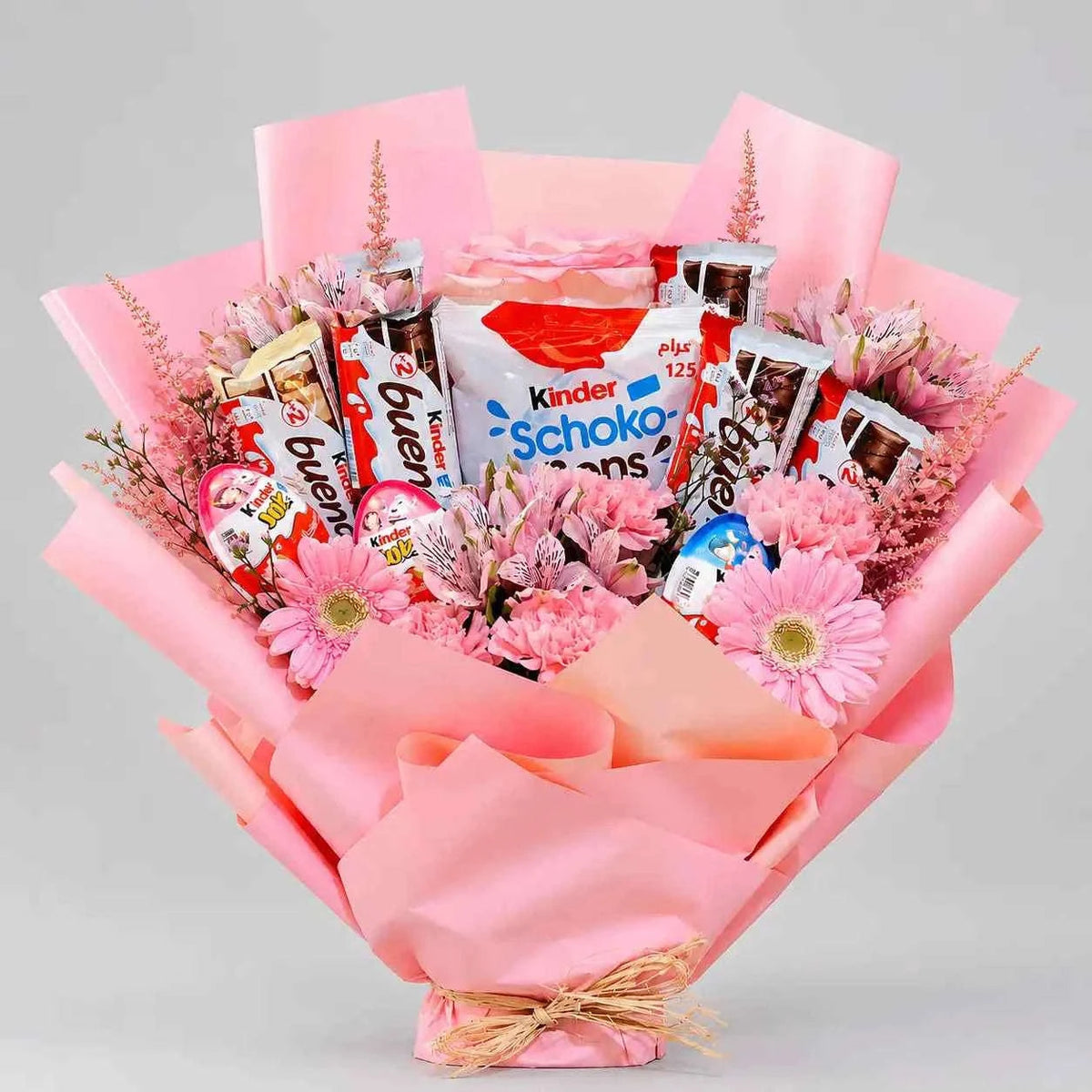 تنسيق زهور وردية طازجة مع شوكولاتة كيندر وتغليف أنيق flowerna