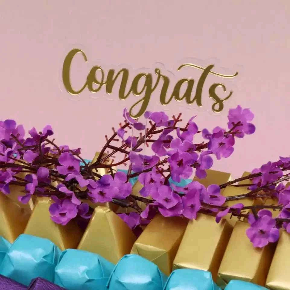صينية شوكولاتة مزينة بأزهار الكرز مع تشكيلة فاخرة من الشوكولاتة flowerna