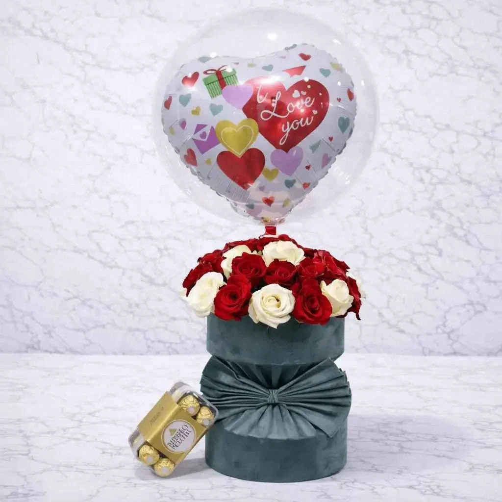 ورود حمراء وبيضاء داخل صندوق مخملي زيتي مع فيريرو روشيه وبالون حب flowerna