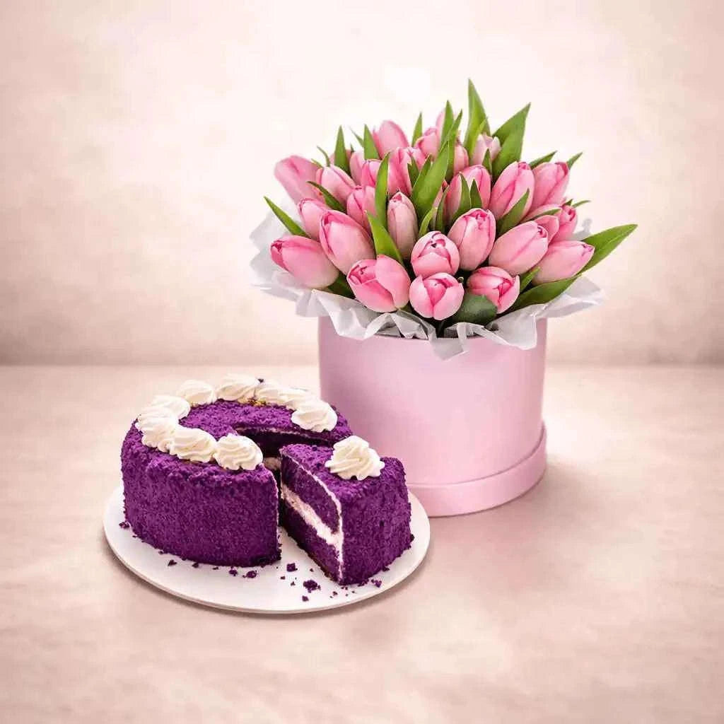 زهور توليب وردية داخل صندوق زهور مع كعكة بنفسجية مزينة flowerna